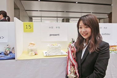 画像:トロフィーを抱える学生